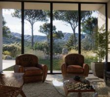 Salon d?une maison contemporaine &agrave; N&icirc;mes largement ouvert sur un jardin m&eacute;diterran&eacute;en et le paysage