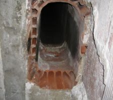 Vue en dessous du boisseau Après suppression des gaines de récupération de chaleur fixés au platre. 
On peut y voir à l'intérieur un trou d'un peu plus de 10 cm de diamètre qu'il va falloir boucher.

Le bas du boisseau a été grignoté tout autour :( Il va falloir aussi combler pour faire un joli plafond et protéger le béton.