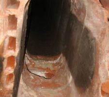 Sur cette photo on voit bien les deux trous de part et d'autre du boisseau ainsi que l'emplacement ou était fixé au plâtre les gaines (boisseau non noirci)