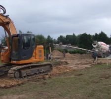Le camion de livraison est arriv&eacute; avec le tapis pour couler les fondations . La pelle a chenille termine le chemin d' acc&eacute;s .