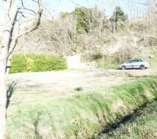 Photo du terrain vue sud est avec construction voisine au nord ouest et entr&eacute; du terrain au nord est