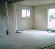 Le salon s&eacute;jour est enduit . La gaine pour l' air chaud en attente de la chemin&eacute;e