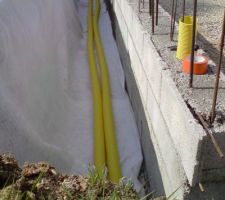 Pose de deux drains, une partie du mur est enduite pour étanchéité (futur garage)