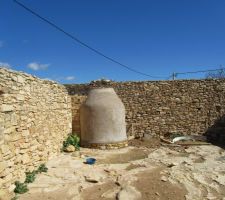 Bain mort (hammam traditionnel) dalle de pierre en dessous. genre de hutte en roseau recouvert de ciment intérieur et extérieur, petite briques rouge au sol et cheminée. chauffage au bois ; cuve en fer (récup d'un ballon ) pour chauffer l'eau.