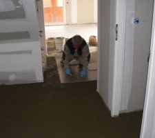 Un des carreleurs en action dans le hall d'entr&eacute;e