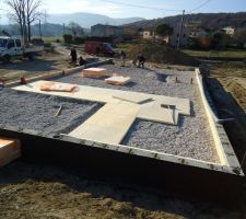 Pose des plaques isolantes sur le gravier avant coulage de la dalle