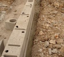 Voir plan du VS : mur de refend pose a moitie sur sa fondation et a moitie sur un lit de mortier pose sur la terre a cote !!!