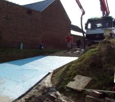 Coulage du béton par mixo compte tenu de la longueur du chantier et de sa préparation qui ne permettait pas un passage aisé de brouettes. Le béton est tiré, lissé au platoir puis traité un désactivant (de couleur bleue) à l'aide d'un pulvérisateur de jardin.