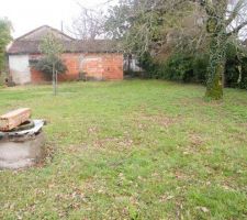 Façade ouest avec extension en briques existante et jardin avec puits