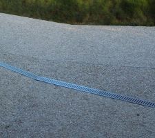 Vue de près : grain du béton, canniveau et rails de dilatation