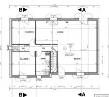 Deux chambres d'à peine 10 m2 et un bel espace de vie avec une cuisine ouverte et un conduit de cheminée central.