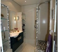 Une douche à l'italienne réalisée avec de la mosaïque circulaire.
Utilisation d'une tringle à rideau de douche symétrique d'angle 95 x 95 en inox brossé.