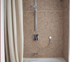 La baignoire asymétrique devient une cabine de douche très confortable associée à une tringle de rideau de douche asymétrique qui épouse parfaitement la forme de la baignoire.