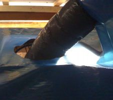 Détail du passage du tuyau de VMC au travers du pare-vapeur. Un trou dans le pare-vapeur, raccord à la bouche installée dans le faux-plafond. L'étanchéité est assurée par une rustine découpée dans le rouleau de pare-vapeur, passée autour du tuyau puis mastiquée, scotché sur le pare-vapeur et le tuyau.