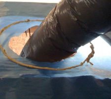 Détail du passage du tuyau de VMC au travers du pare-vapeur. Un trou dans le pare-vapeur, raccord à la bouche installée dans le faux-plafond. L'étanchéité est assurée par une rustine découpée dans le rouleau de pare-vapeur, passée autour du tuyau puis mastiquée, scotché sur le pare-vapeur et le tuyau.