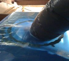 Détail du passage du tuyau de VMC au travers du pare-vapeur. Un trou dans le pare-vapeur, raccord à la bouche installée dans le faux-plafond. L'étanchéité est assurée par une rustine découpée dans le rouleau de pare-vapeur, passée autour du tuyau puis mastiquée, scotché sur le pare-vapeur et le tuyau.