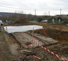 Dalle de propreté coulée. On aperçoit la cave à droite. Une dalle est coulée au fond, et en dessous un puisard
