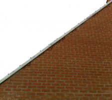 A certains endroits le maçon avait remplacé une brique par du ciment... comme il manque une rangé de brique sur chaque pignons (confirmé par le CDT), cela était flagrant ! alors au lieu d'enlever le ciment et mettre des brique, il a mis des bouts de briques ici et là... les joints ne sont pas sec sur la photo. Mais on peut déjà remarquer le travail de porc !... Le maçon ne se donne même pas la peine d'enlever le zinc pour travailler proprement.