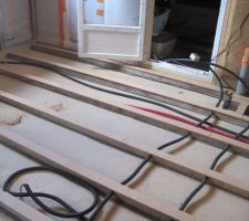 Pose des gaines d'&eacute;lectricit&eacute; et de plomberie entre les lambourdes de la cuisine