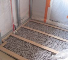 &eacute;pandange de la ouate de cellulose (&agrave; la main) entre les lambourdes de la cuisine