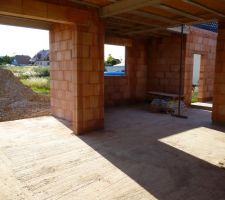 Allant de la gauche vers la droite, vue sur le salon avec porte fenêtre, la cuisine au milieu et le garage avec porte de service