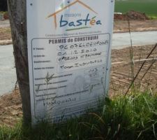 Installation du panneau de permis de construire sur le terrain