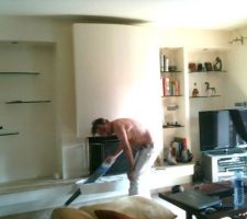 Dans la continuité de la cuisine ( desormais totalement ouverte) le coin cheminée que nous allons modifier pour qu'il soit dans le même esprit que la cuisine, voilà donc son relooking ! on va scier le béton pour rendre la banquette et l'avant foyer linéaire, puis démolition le coin niche bibliothèque pour agrandir la niche en vue de la réalisation d'un meuble TV intégré conçu pour recevoir les équipements vidéo et home cinéma ( caisson de basses compris )
