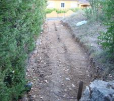 Vue du cot&eacute; interieur en haut de la pente.  La hauteur du mur sera de 1m juste devant &agrave; 1m du bord propri&eacute;t&eacute; et de 1.8 au fond de la photo.(en haut ).
on voit les diff&eacute;rents niveaux de terrassement pour que la semelle soit horizontale.
&agrave; gauche les cypr&eacute;s c'est chez le voisin.