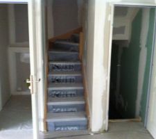 Escalier qui mène à l'étage avec WC suspendu à gauche. A roite, escalier qui mène au sous sol complet