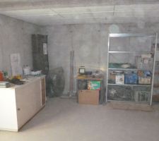 Partie de la cave aménagée avec meuble, table, rayonnage métallique et servant de QG