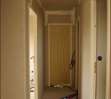 Le couloir, en fond la suite parentale, a gauche la chambre d'ami, la première a droite les toilettes, la seconde à droite la salle de bain.