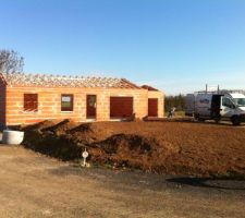 Les fermettes sont en place et la charpente traditionnelle est en cours sur le garage
