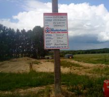 Le panneau de chantier avec une vue sur le terrain