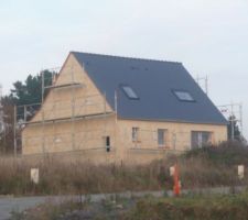 Première couche de l'enduit.Les murs vont être recouverts d'un enduit étanche. Notre enduiseur utilise les produits Weber-Broutin et travaille en deux couches.Protection des portes, des fenêtres, le dessous des ardoises, la toiture.La couleur est jaune opale J30.