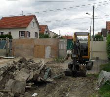 La petite pelle &agrave; d&eacute;molie le muret qui donne vers la rue, pour le passage futur de la grosse pelle.