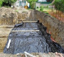 Après assèchement du terrain (car eau provenant de la nappe en dessous), pose d'un isolant contre humidité et ferraillage pour les semelles de la maison.