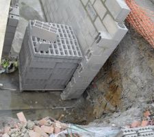 Élévation des murs du sous-sol. Eau visible...
Il n'y pas eu de drain du coté droit.
Les parpaings sont de type classic : le constructeur ayant dit "à bancher" au rdv de l'expert judiciaire!...
