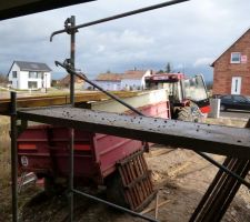 Etanchéité du garage: mise en place du gravier de lestage. Le gravier a été monté à la pelle de la remorque jusqu'à la brouette placée sur le toit