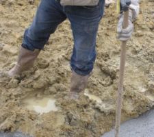 Le petit appareil jaune fixé sur le manche du support permet de voir pendant le coulage du béton dans les fouilles si le niveau supérieur du béton atteint bien la hauteur souhaitée