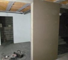 Travaux dans la cave: mur fraichement crépi et au fond mur peint