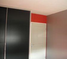 Coté porte et placard, deux murs gris, et deux rouges