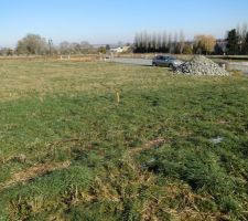 Plantage de batons pour jalonner l'emprise de la maison, et arrivée des cailloux pour la rade de chantier !