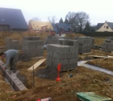 Apr&egrave;s avoir coul&eacute; le b&eacute;ton, ils commencent &agrave; &eacute;lever les parpaings du vide sanitaire.