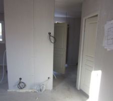 Vue sur la porte d'entrée (en face), la chambre 1 (à droite)
