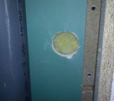 Un trou dans le placo de la chute d'évacuation.