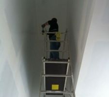 Premières couches de peinture dans la cage d'escalier après ponçage
