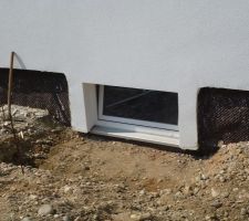 Aménagements extérieurs: excavation autour de la fenêtre de cave en vue de la pose de bordures