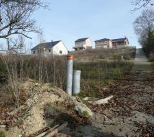 Une vue du bas du terrain qui est situ&eacute; sur la gauche. On appercois les &eacute;vacuations EU et EP. La voie et un chemin pieton.