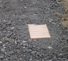Brique sur chemin d'accès posée pour indiquer la hauteur finale du remblai (plot de niveau)