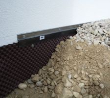 Vue de coupe de la bordure le long de la maison: Delta-MS   profilé de finition avec une sous couche de tout venant et une couche de finition en granit